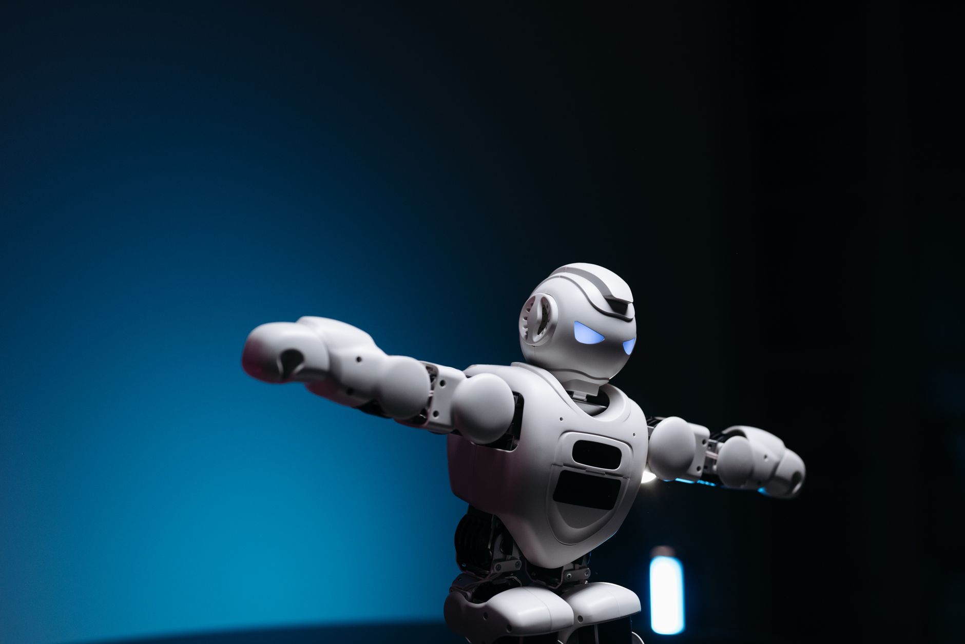 Close-up of a futuristic robot toy with glowing eyes against a blue background, symbolizing innovation.