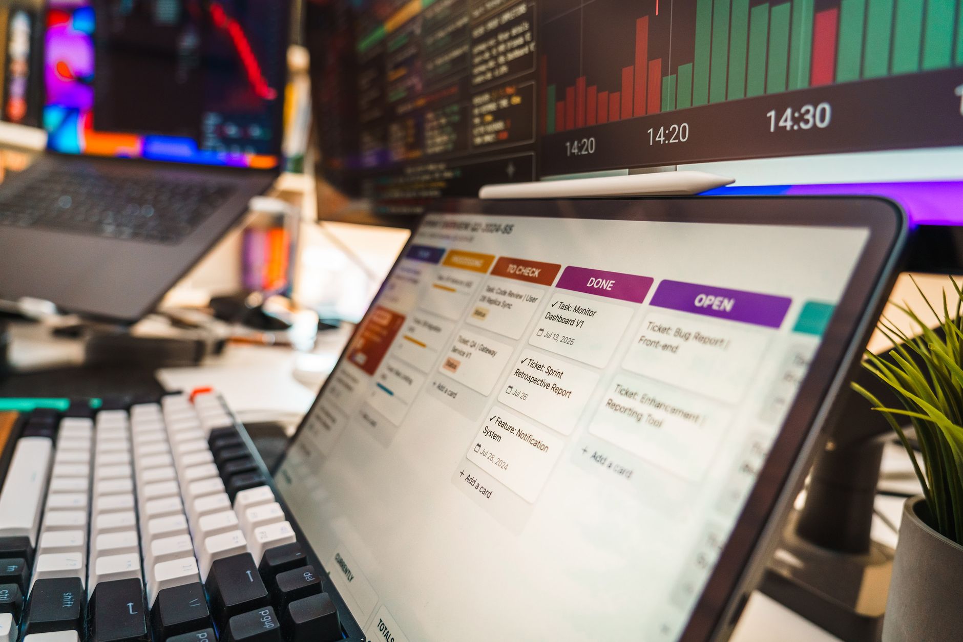 A dynamic office setup featuring multi-screen displays with data charts and project management tools, perfect for tech or business environme