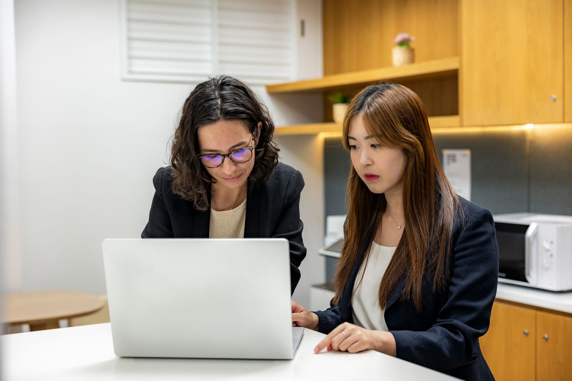 Two professionals working together in a contemporary office environment with technology.